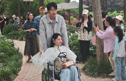 金莎录节目崴脚坐轮椅，工作室回应因鞋跟太高，丈夫贴心搀扶引热议