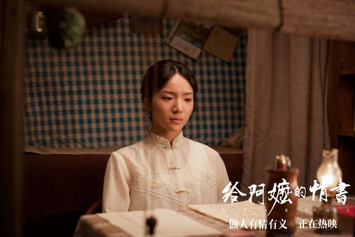 在电影中,李思潼饰演的谢南枝需要模仿1940年代侨眷的笔迹,为不识字的阿嬷代写家书。为了练出符合年代感的小楷,她每天泡在档案馆临摹侨批原件,指尖磨出了厚厚的茧。有一场戏,她蹲在灶台前为阿嬷朗读信件,84岁的素人演员吴少卿即兴加了一句潮汕话:“阿妹,你读得像我阿孙。”李思潼当场被触动,声音颤抖,将台词念成哽咽,这段即兴表演被完整保留在成片中。如今,全国的观众走进影院,都会因为这个细节而红了眼眶——原来最动人的表演,从来不需要技巧,只需要将心放进角色的人生里。 从5月12日开始,《给阿嬷的情书》上演了一场神奇的“逆跌”:工作日票房竟比周末还涨了42%,排片占比27%却斩获65%的票房。有观众二刷时注意到,当片尾字幕滚动到“侨批原件提供者”时,影厅里的抽泣声比正片更响亮。李思潼在近期的路演中分享,有位90岁的潮汕阿嬷拉着她的手说:“我的阿兄当年去暹罗,也是这样写信回家的。”这个从图书馆走出的女孩,也许还未完全适应闪烁的聚光灯,但她已经用最朴素的方式,让观众读懂了什么是“中国人的情义”。如今,她的金融课本仍静静放在宿舍书桌上,只是扉页多了一行字:“表演和理财一样,真诚才是最好的算法。”